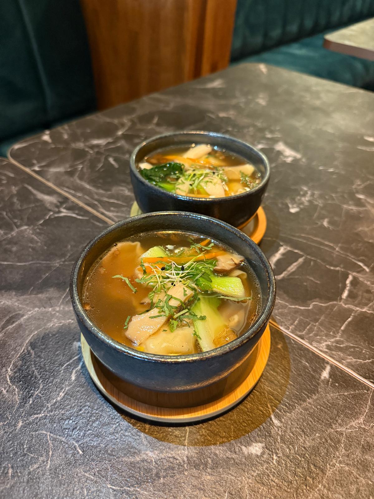 Tom Yum Tofu mit hausgemachten Nudeln, frischem Gemüse und Kräutern in würziger Kokosbrühe