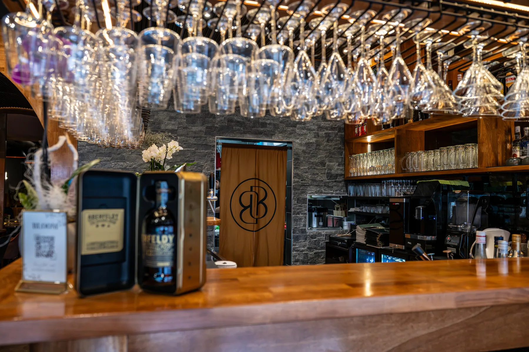Bar bei Bloom mit hängenden Gläsern und warmem Licht