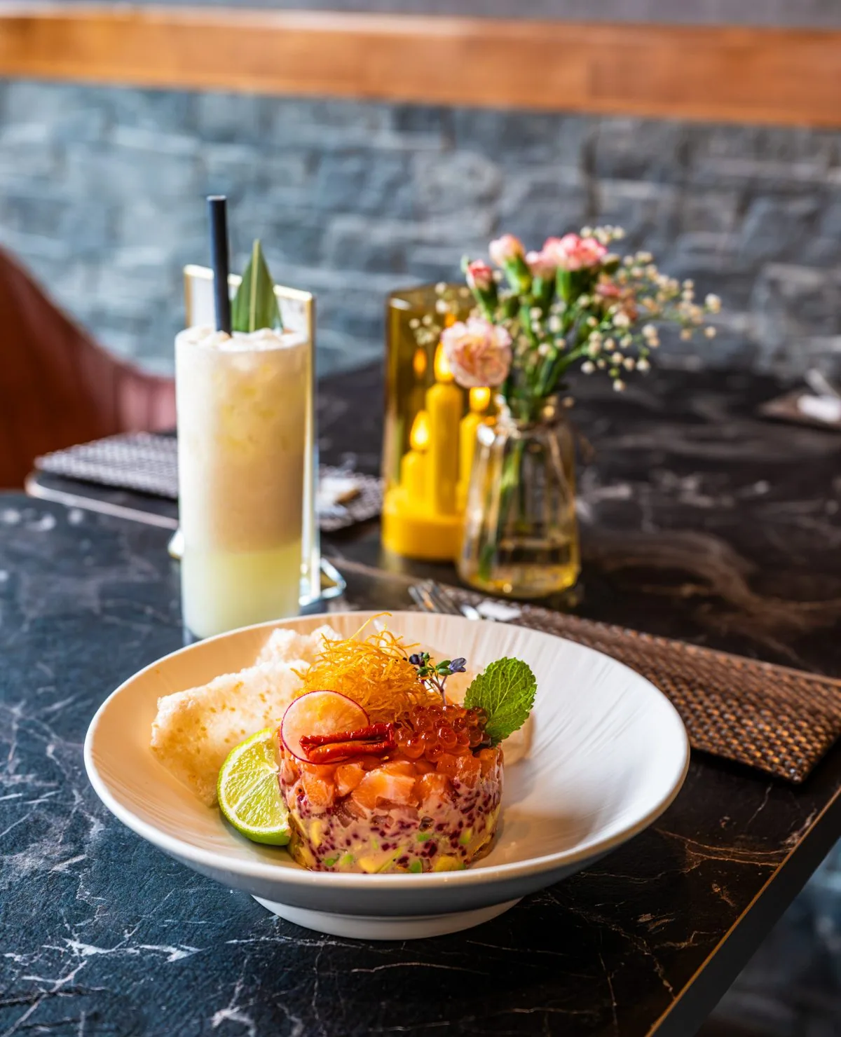 Vorspeise und Cocktail auf dunklem Marmortisch bei Bloom